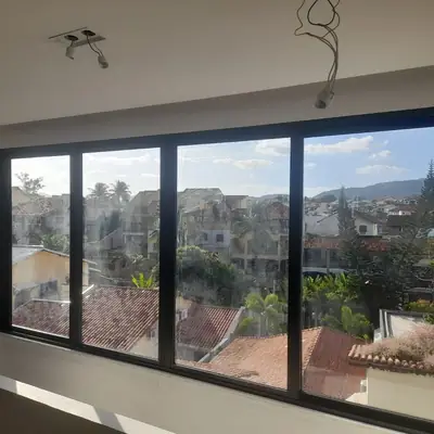 Janela de alumínio preta de quatro folhas com vista para o bairro