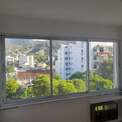 Janela de correr branca de três folhas em quarto