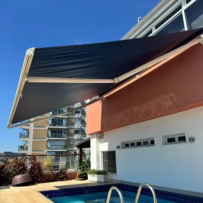 Toldo retrátil escuro sobre a piscina na cobertura de um prédio